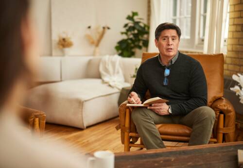 Man sitting in chair with notebook