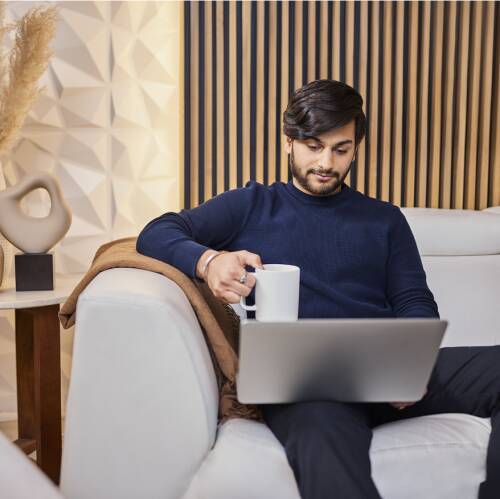 Student using laptop and drinking coffee