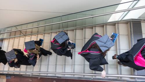Graduates walking together up a flight of stairs