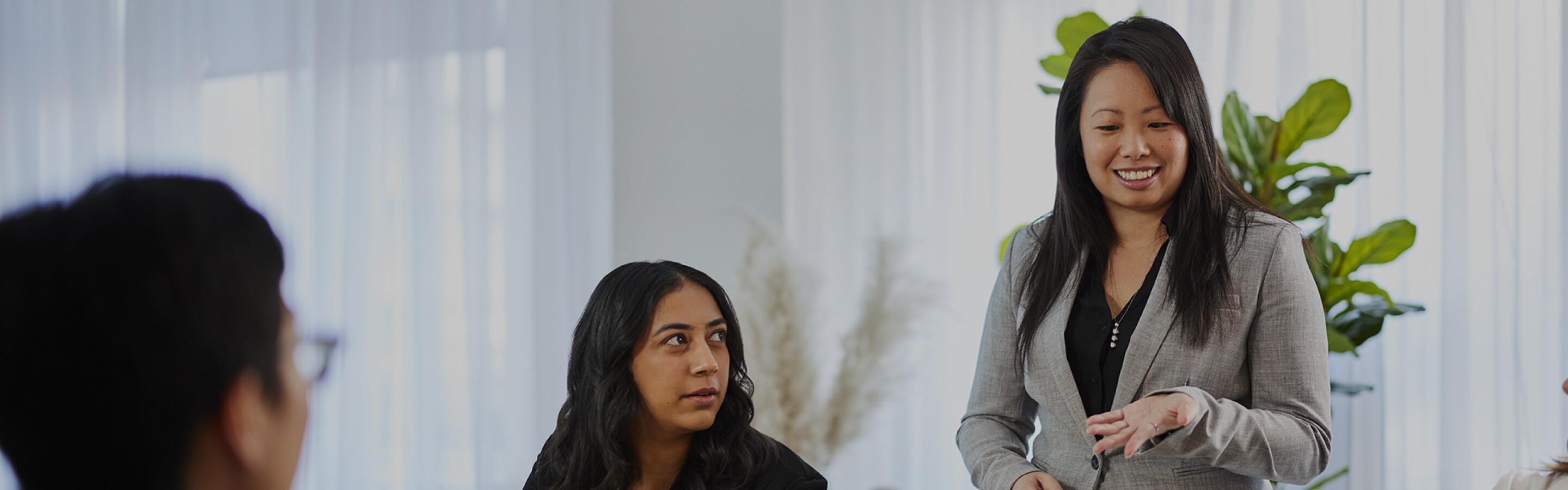 Three woman meeting around a table with laptops