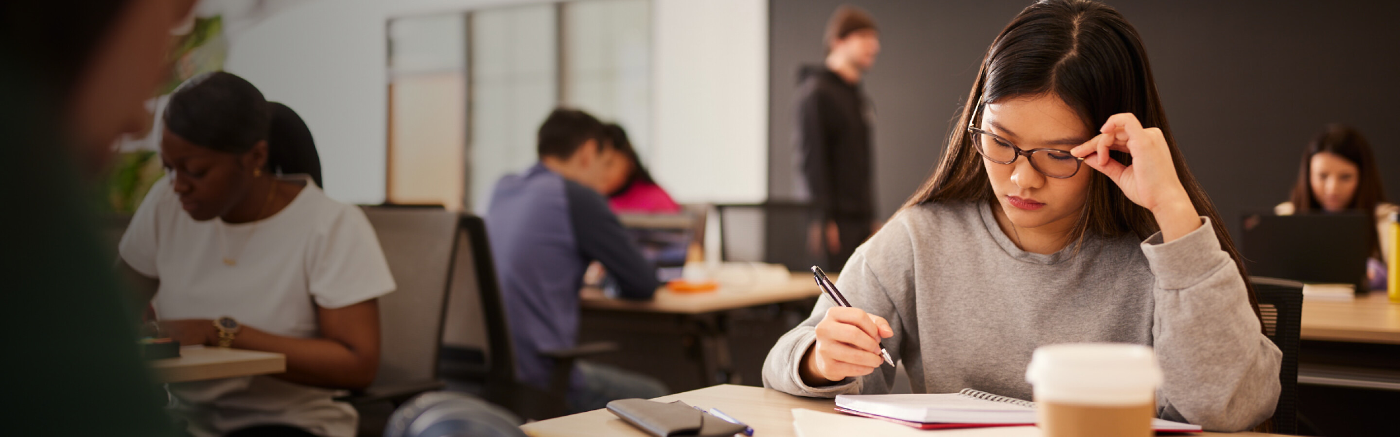 Student working at a table with other students