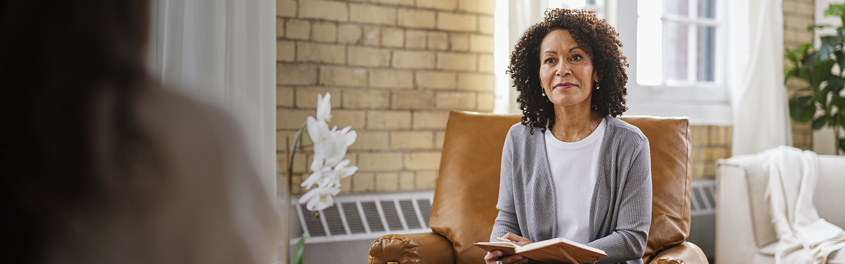 Woman with notebook sitting in counselling office