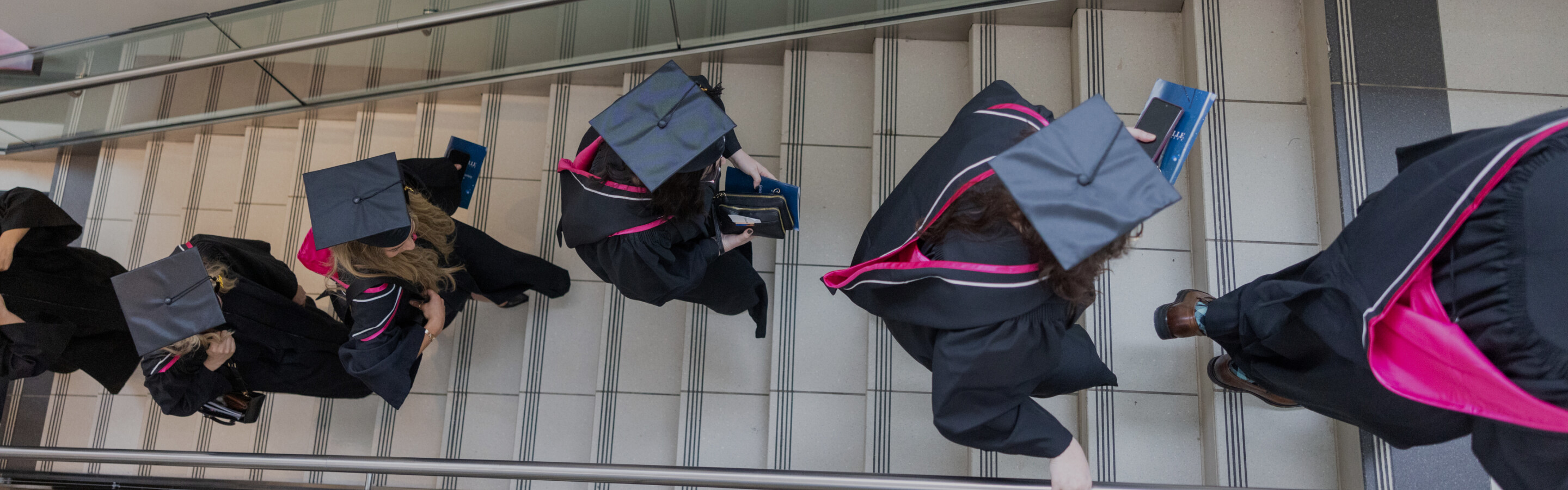 Graduates walking in a line up stairs