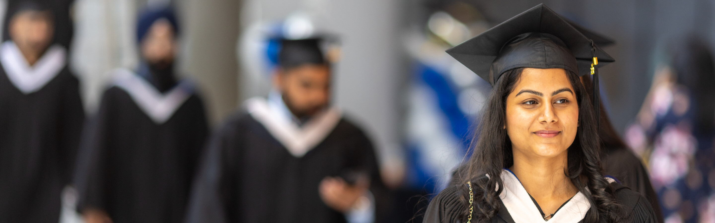 Female graduate walking in her cap and gown