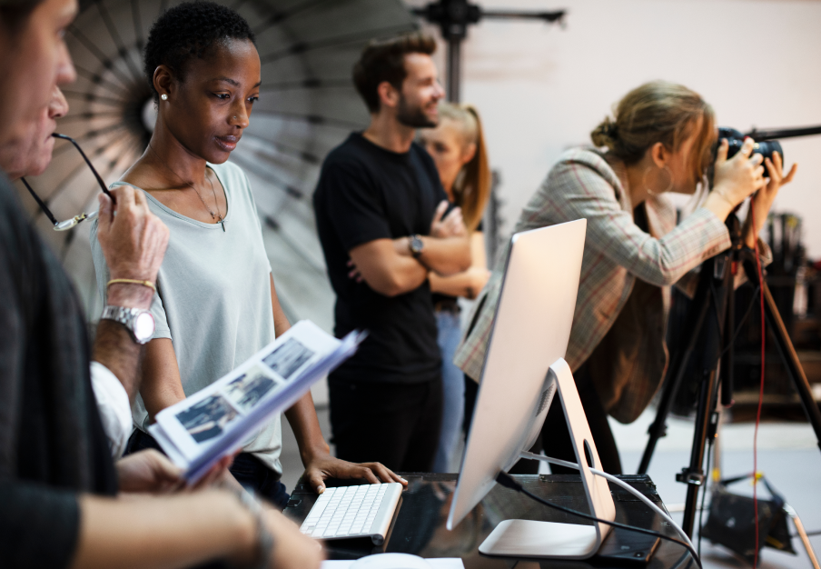 Group of people at a photoshoot, with the photographer taking photos while everyone else looks on